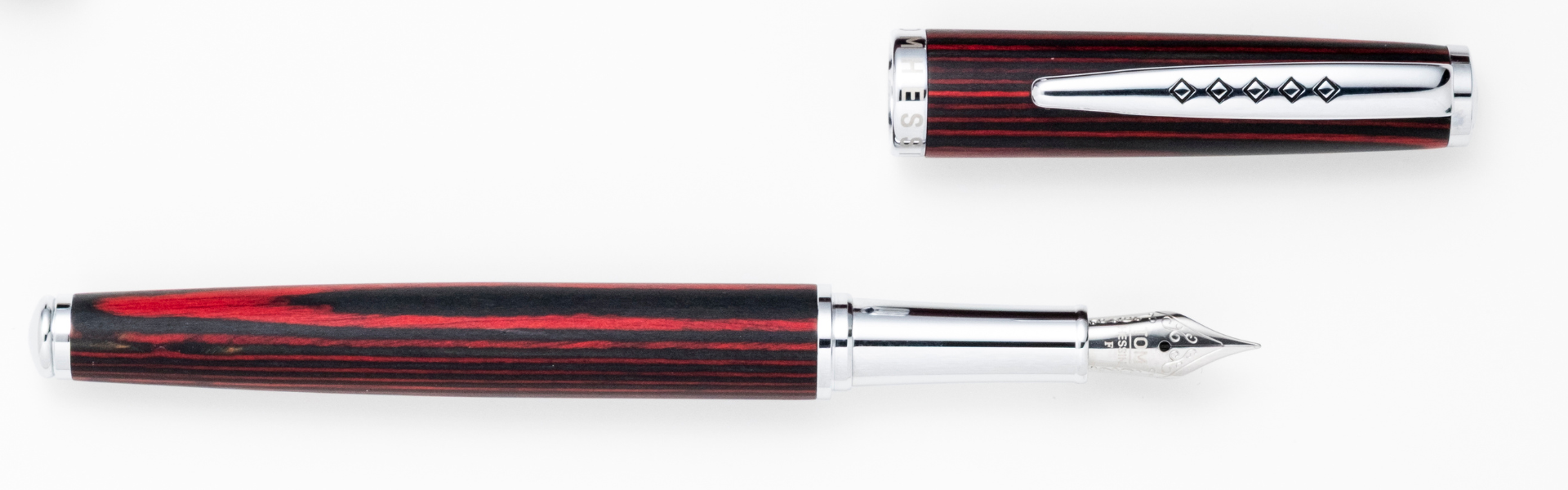 Fountain pen with red and black striped design on a white background