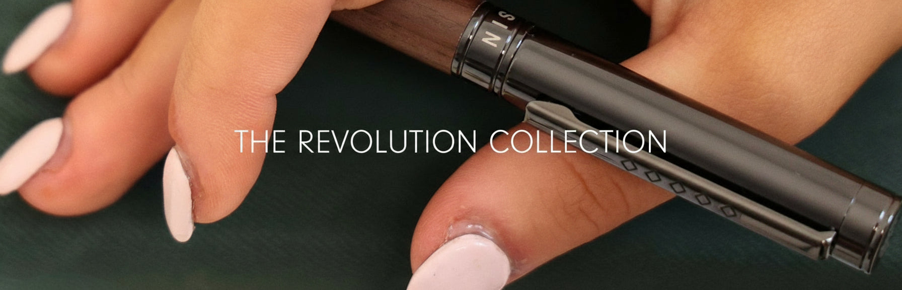 Hand holding a pen with 'The Revolution Collection' text overlay