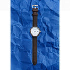 Tom Hessin Revolution Blue watch with brown leather strap and chrome buckle - lifestyle close up
