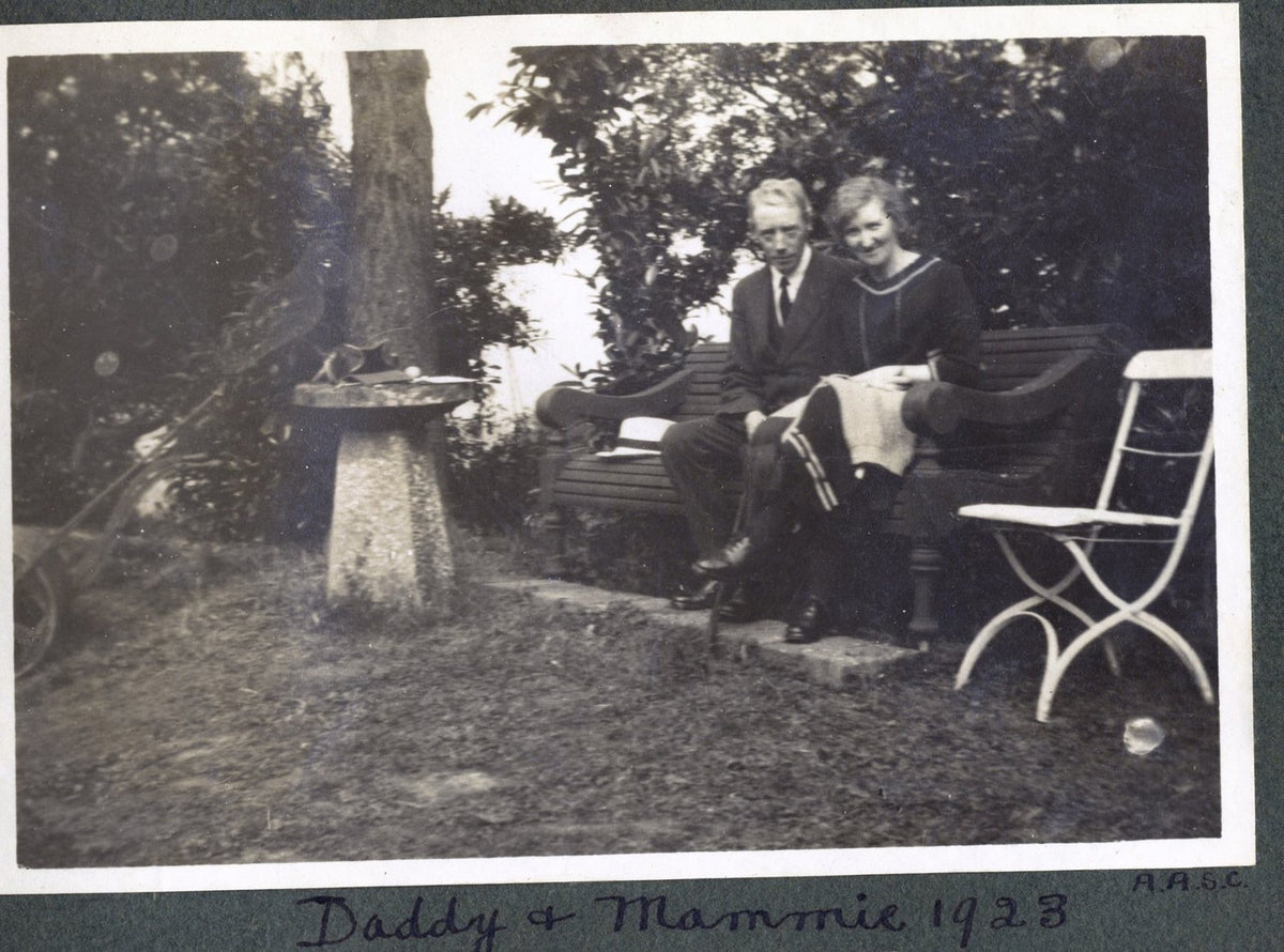 Page from a family photograph album: a man and a woman seated on a garden bench, captioned by hand Daddy and Mammie 1923