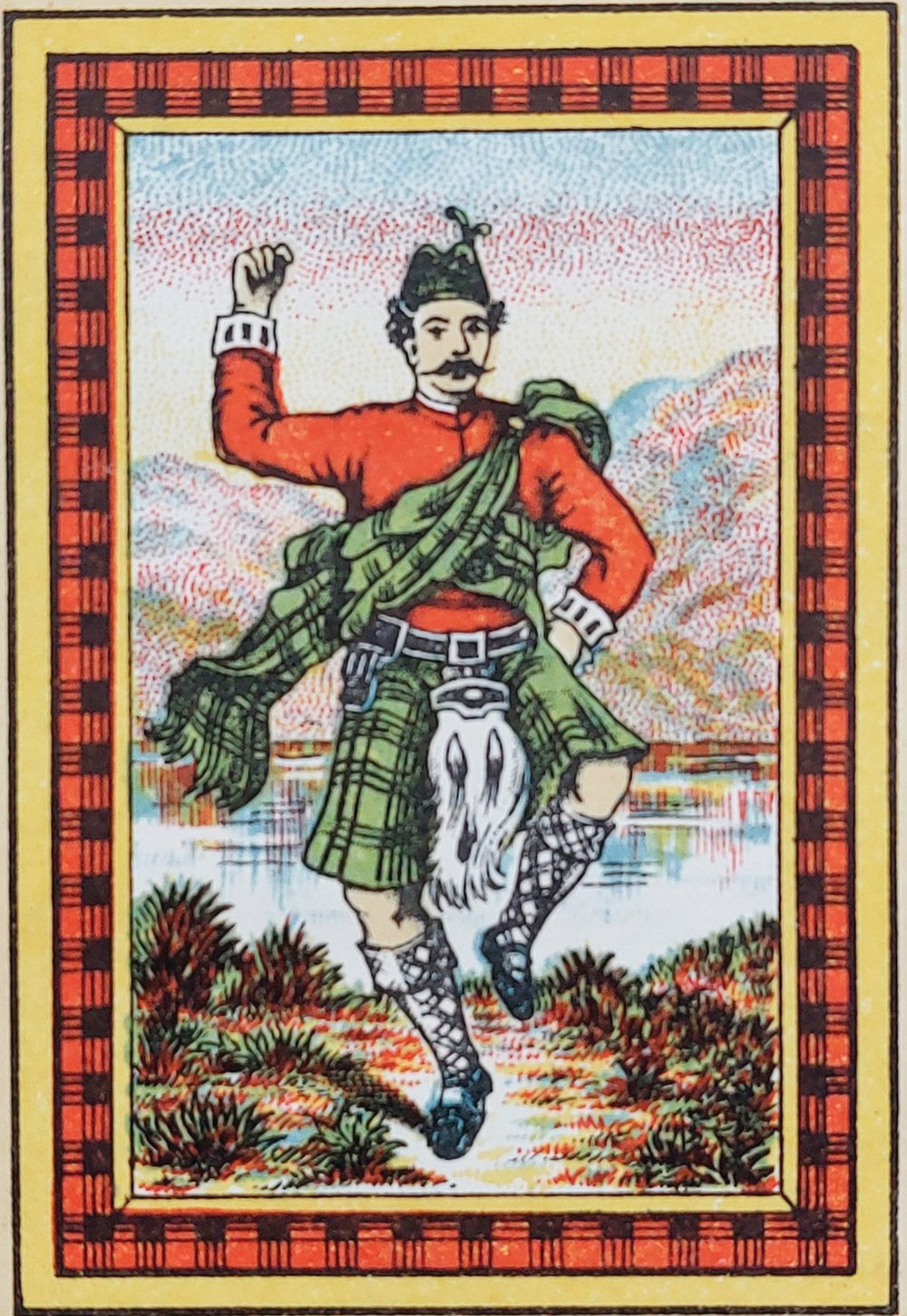 Colour label with a red and black tartan border: a dancing figure in a red jacket and green kilt in front of a loch and hills